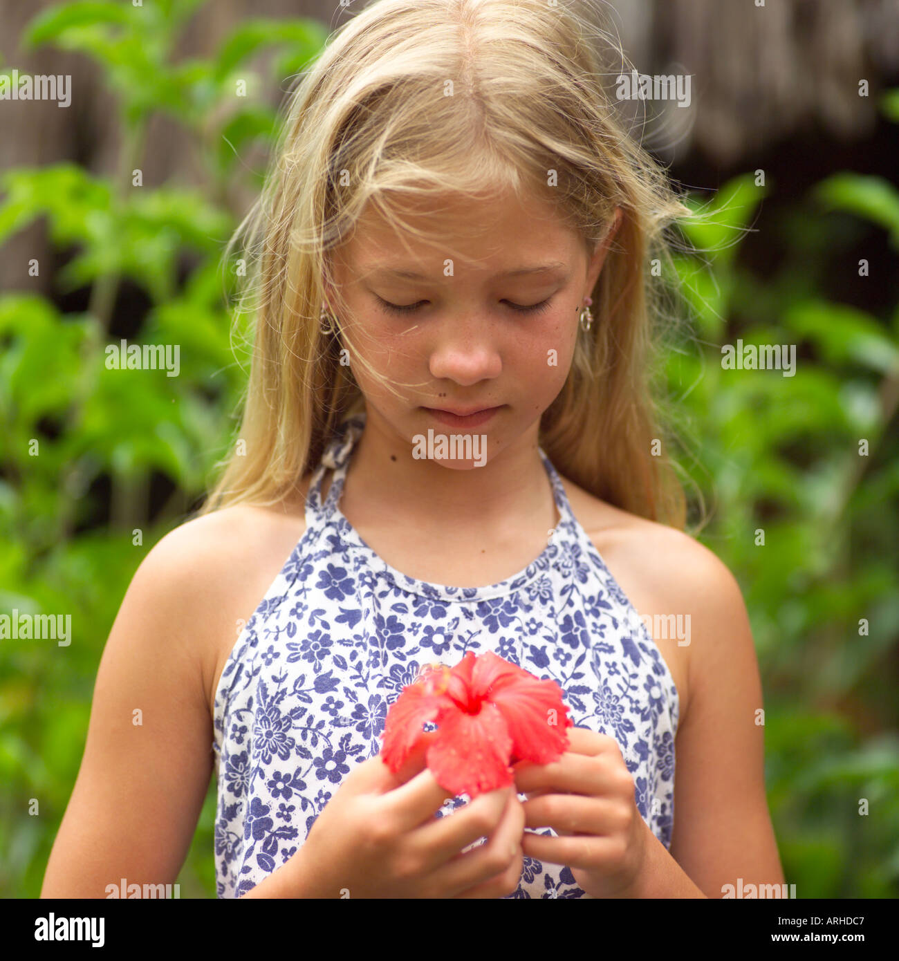 Junge Mädchen halten Blume auf Moorea in Tahiti Stockfoto