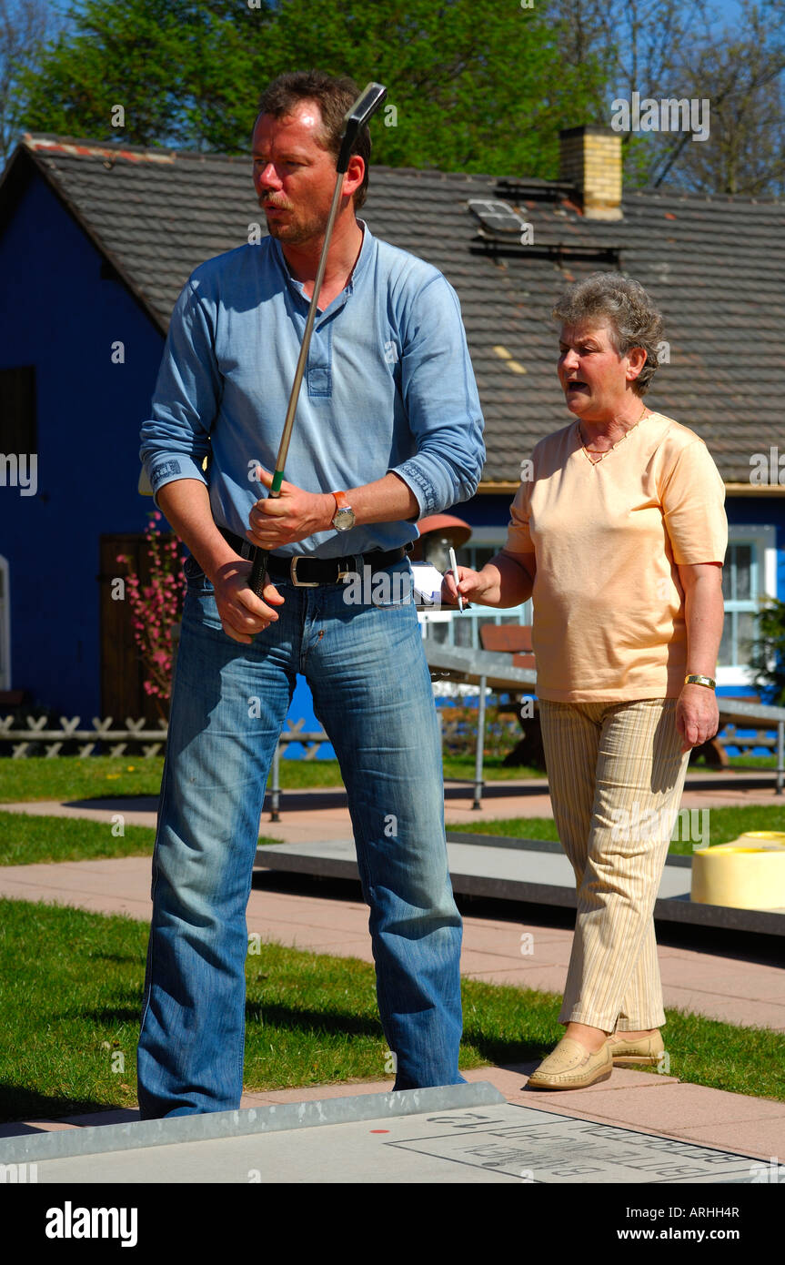 Ältere Frau und junger Mann auf ein Mini-Golfplatz Golf spielen Stockfoto