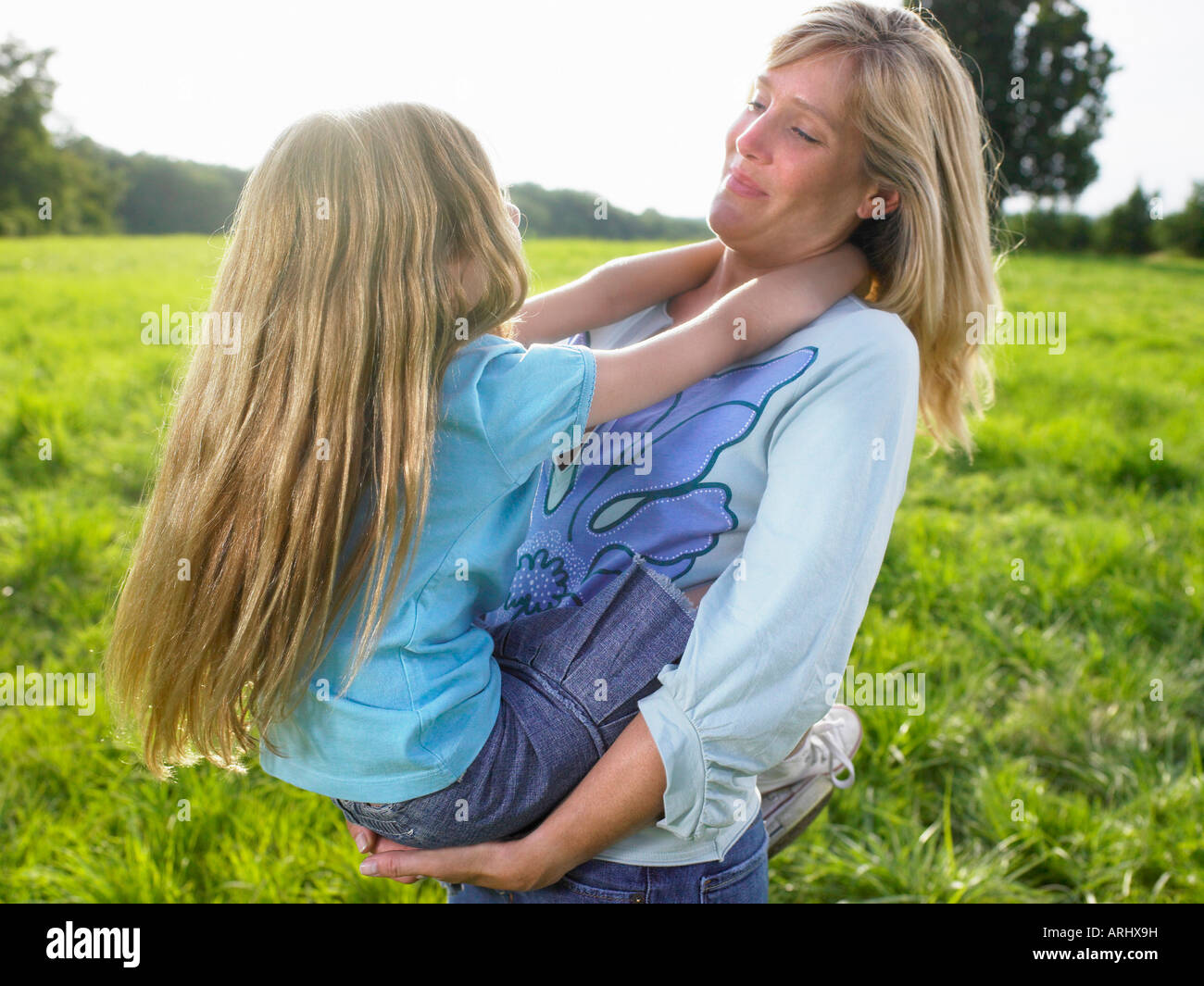 Mutter und Tochter spielen in einem Feld Stockfoto