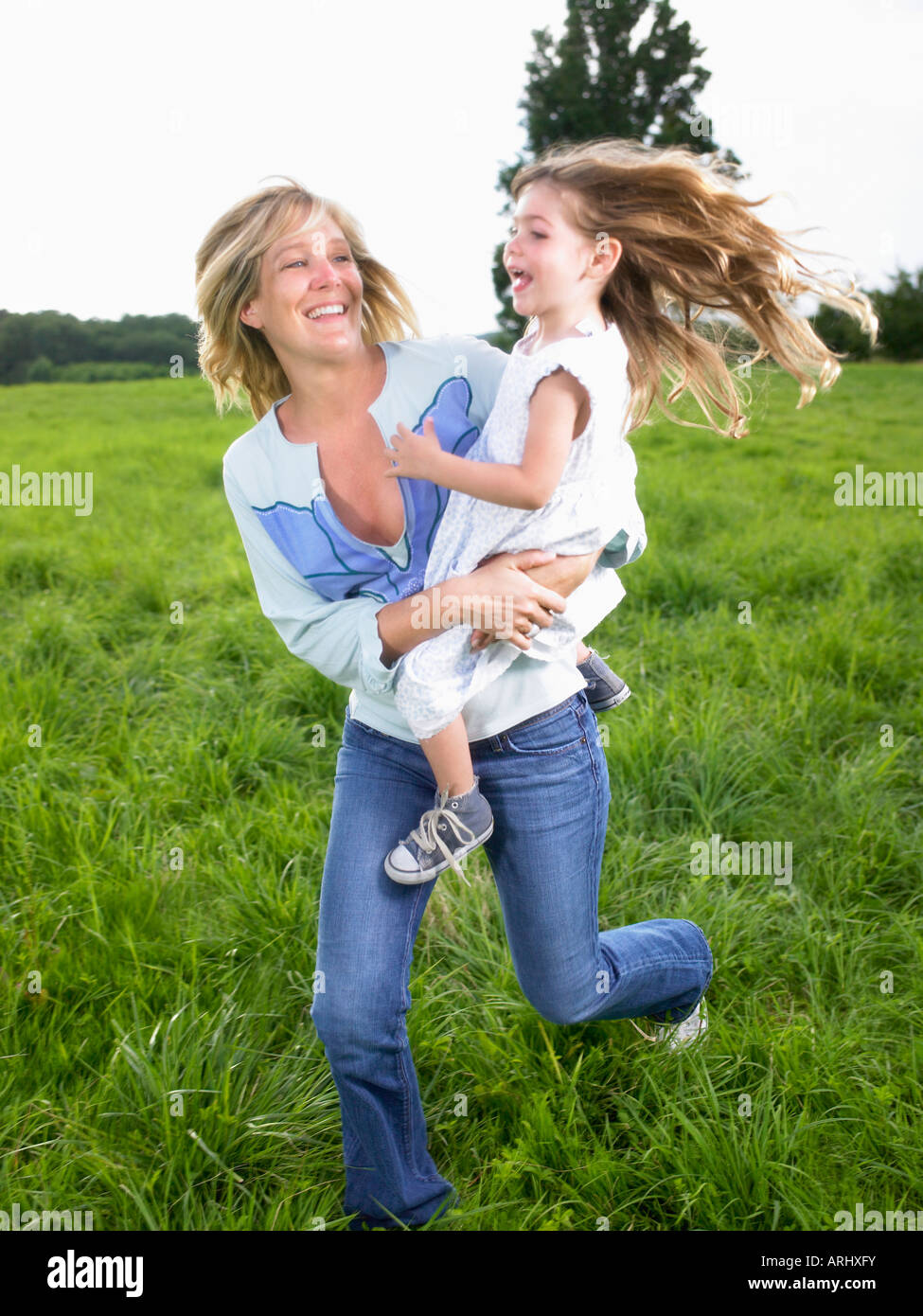 Mutter und Tochter spielen in einem Feld Stockfoto
