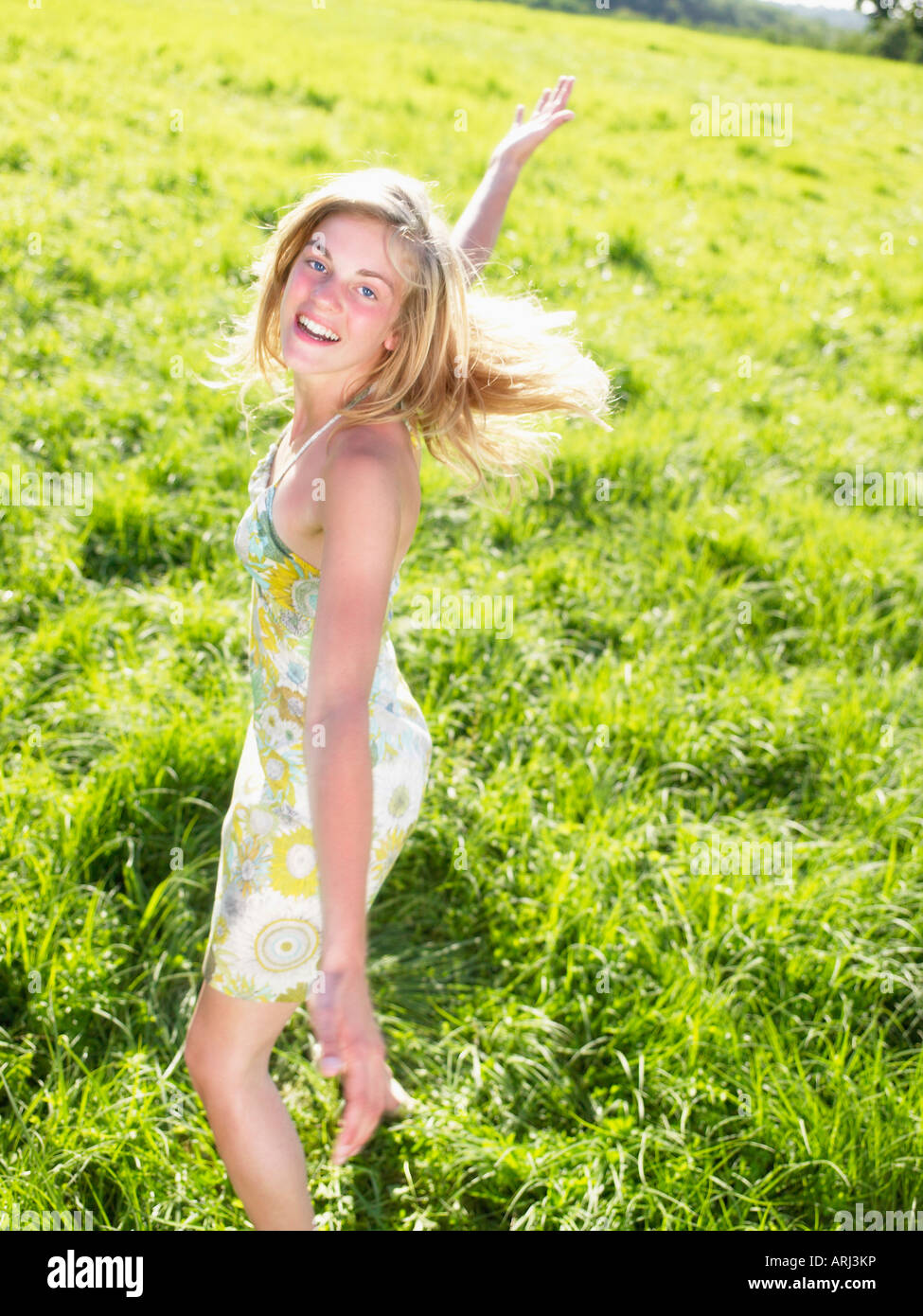 Junge Frau in einem grünen Feld tanzen Stockfoto