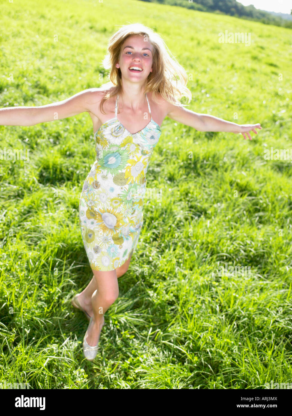 Junge Frau in einem grünen Feld tanzen Stockfoto