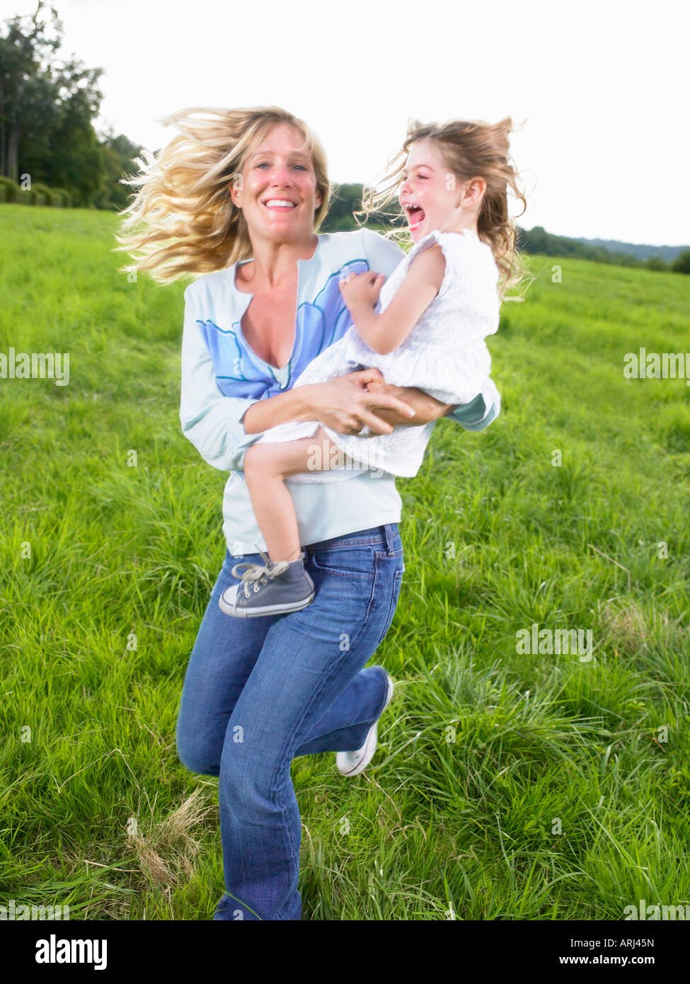 Mutter und Tochter spielen in einem Feld Stockfoto