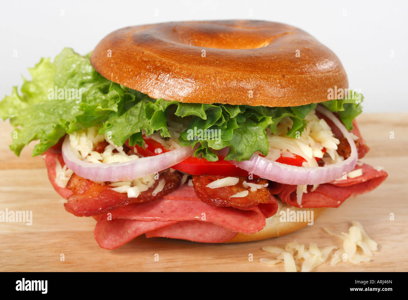 Bagel-Sandwich auf einem Holzbrett weißem Hintergrund mit Gemüse und Schinken Vorderansicht isolierter Ausschnitt Ausschnitt Ausschnitt niemand Großaufnahme horizontal in den USA US Hi-res Stockfoto