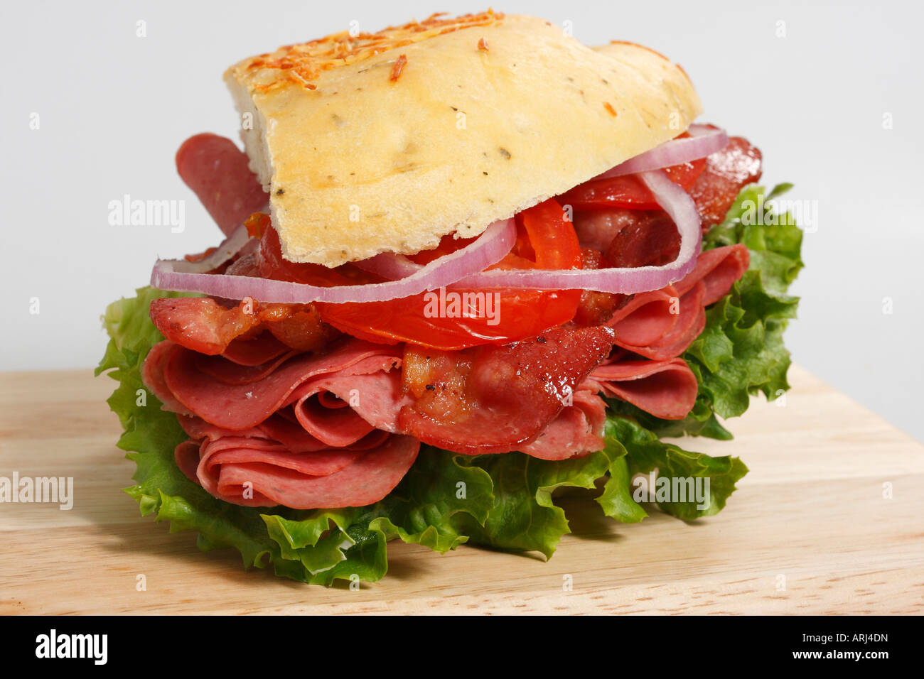 Focaccia-Brot-Sandwich, serviert mit gebratenem Schinken Speck, vegetarischen Speisen auf Holzbrett isolierter Ausschnitt von oben horizontal in den USA Hi-res Stockfoto