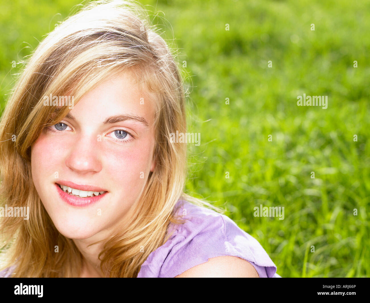 Junge Frau sitzt in einem Feld Stockfoto