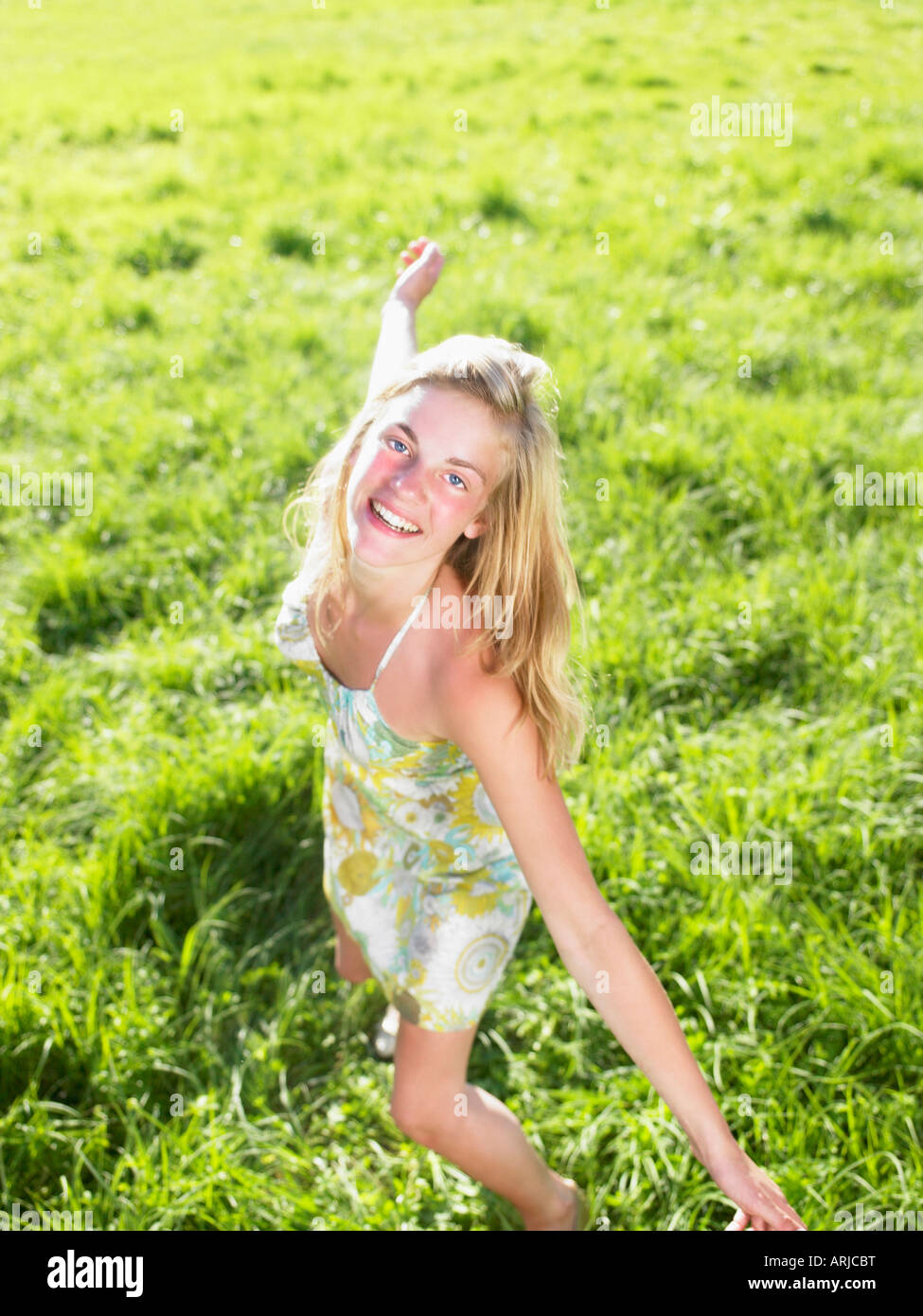 Junge Frau in einem grünen Feld tanzen Stockfoto