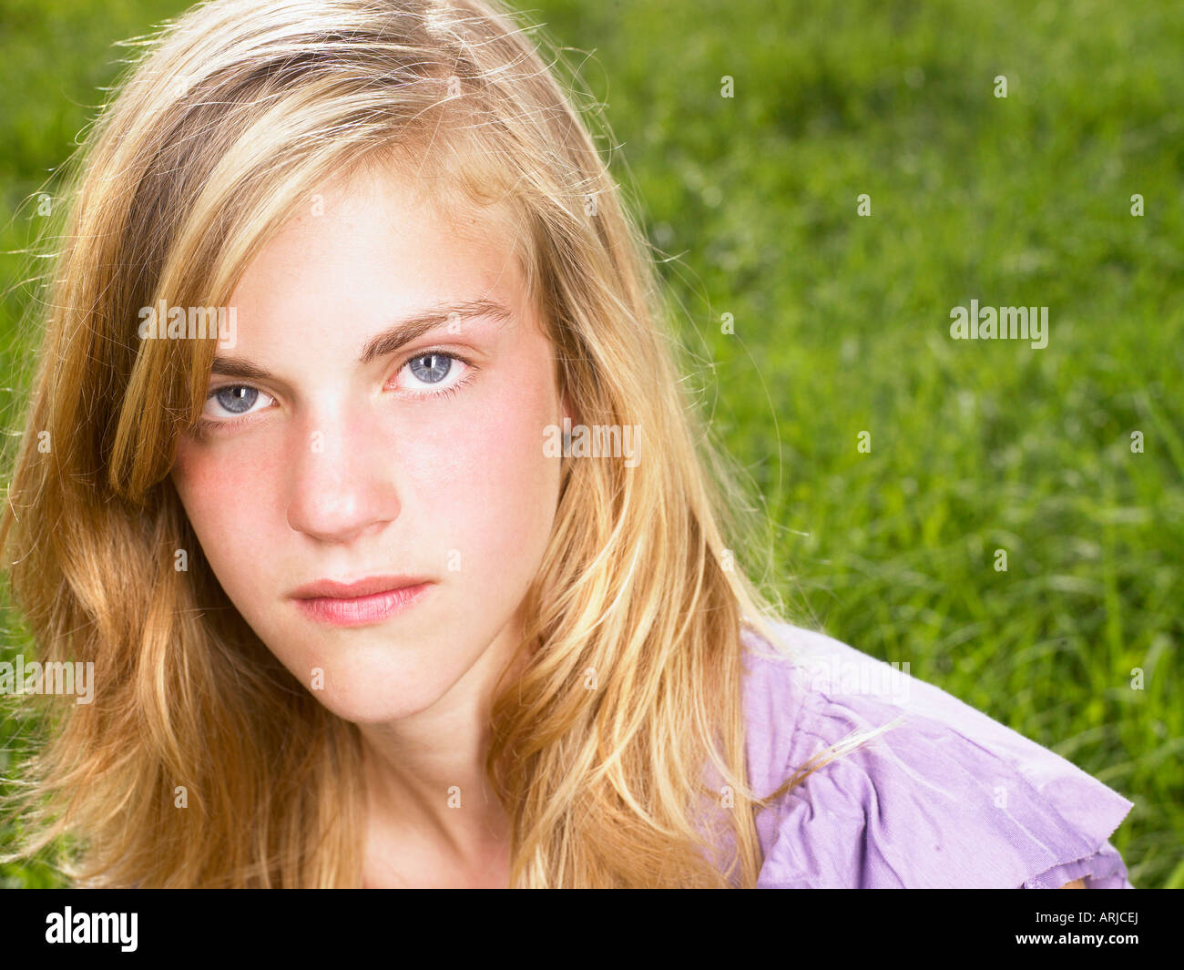 Junge Frau sitzt in einem Feld Stockfoto