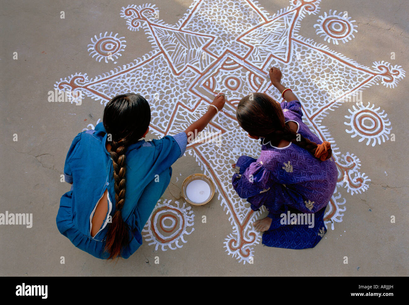 Frauen, die Malerei eine Mandana auf dem Boden, Dorf in der Nähe von Jodhpur, Rajasthan, Indien Stockfoto