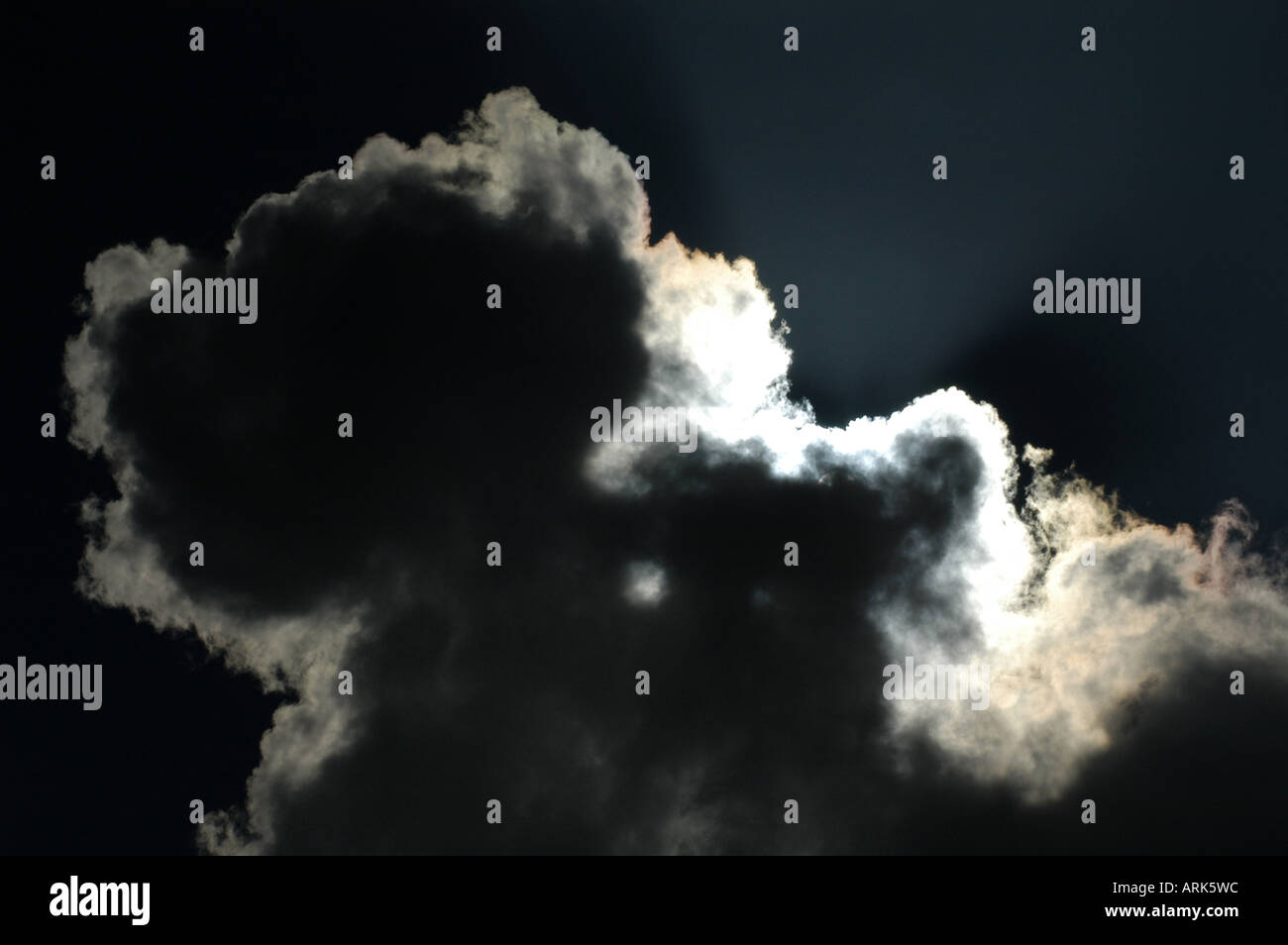 Symbolische Foto: Sonnenstrahlen kämpfen mit einer Wolke. Hoffnung, Zuversicht. Stockfoto