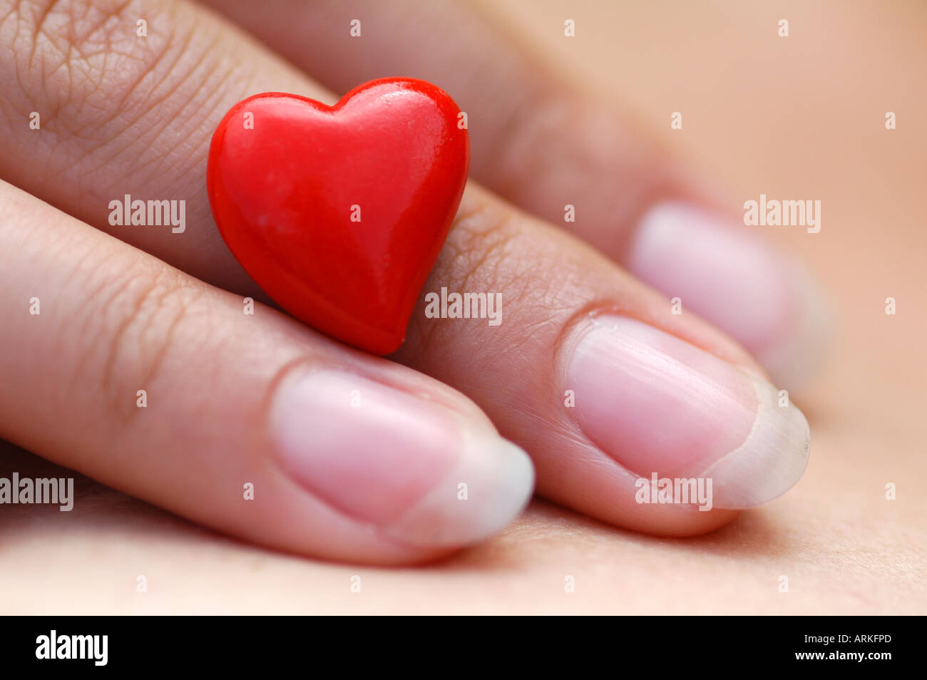Symbolische Foto: zarte Frauenhand mit einem Zwerg Herzen. Liebe. Stockfoto