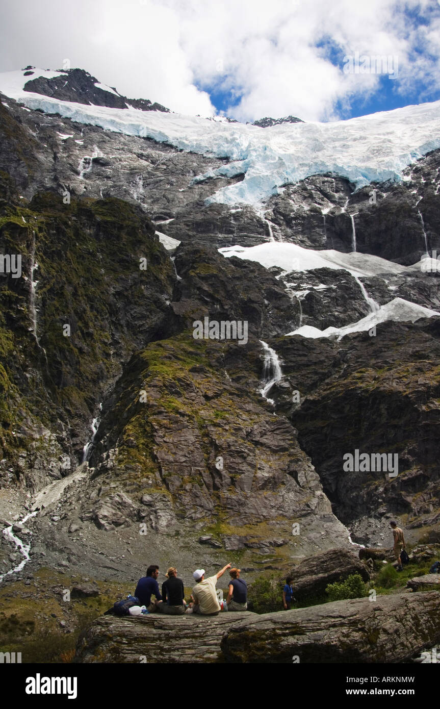 Wanderer sehen Wasser Kaskadierung von Rob Roy Gletscher im Mount Aspiring Nationalpark, Südinsel, Neuseeland, Pazifik Stockfoto