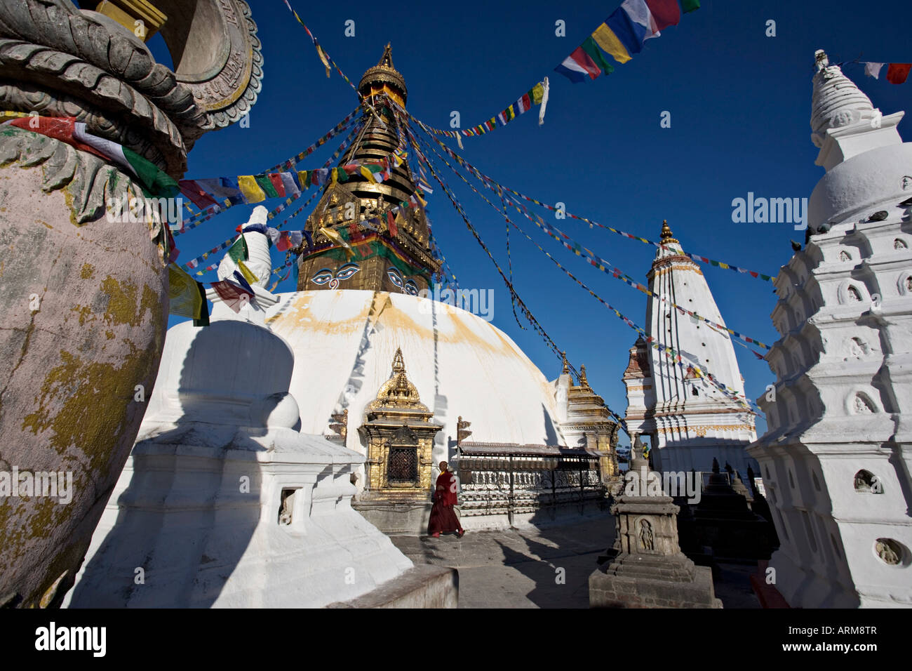 Ein Mönch geht im Uhrzeigersinn um die buddhistische Stupa genannt Swayambhu oder Swayambhunath, Kathmandu, Nepal Stockfoto
