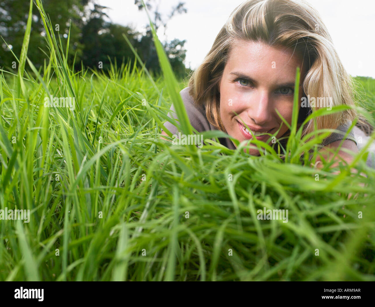 Frau in einem grünen Feld legen Stockfoto