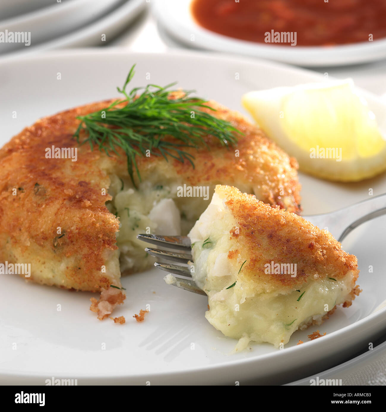 Fischkuchen aufgeschnitten mit Gabel, innen auf weißen Teller Keywords Käse Dill zu zeigen Stockfoto