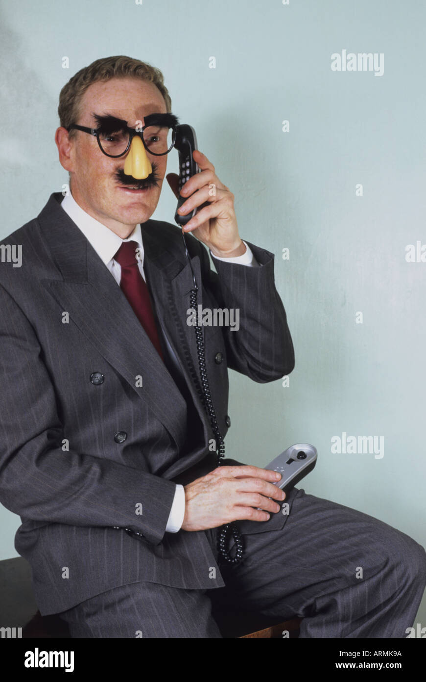 betrügerische Geschäftsmann tragen komische Verkleidung versteckt die Tatsache, dass, die er unehrlich sprechen am Telefon ist Stockfoto