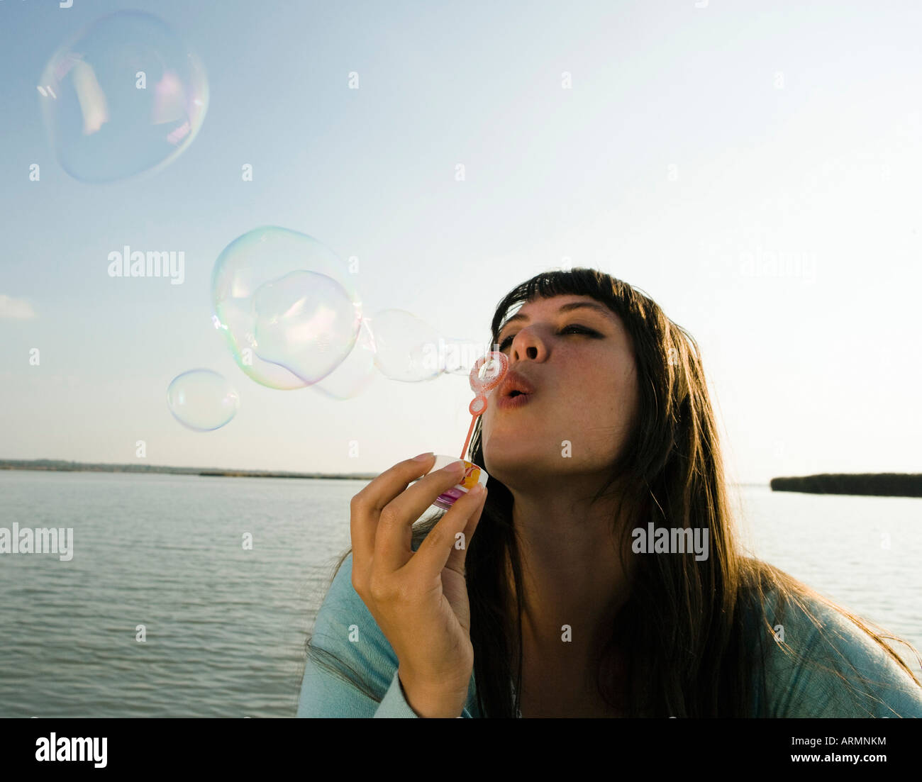 Mädchen blowing Bubbles von See Stockfoto