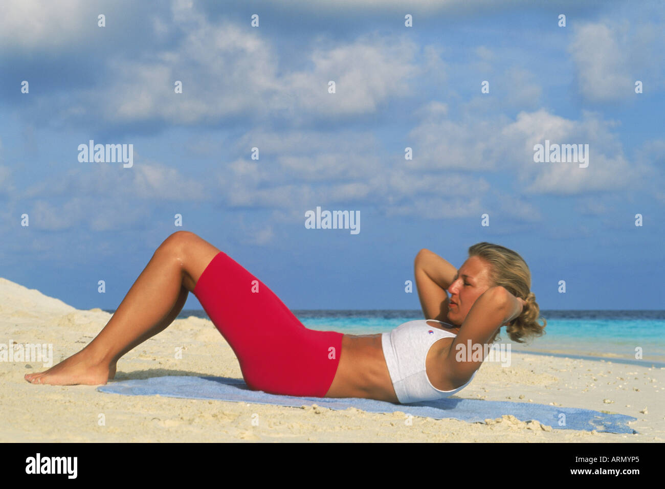 Frau Sit am Strand bei Sonnenaufgang Stockfoto