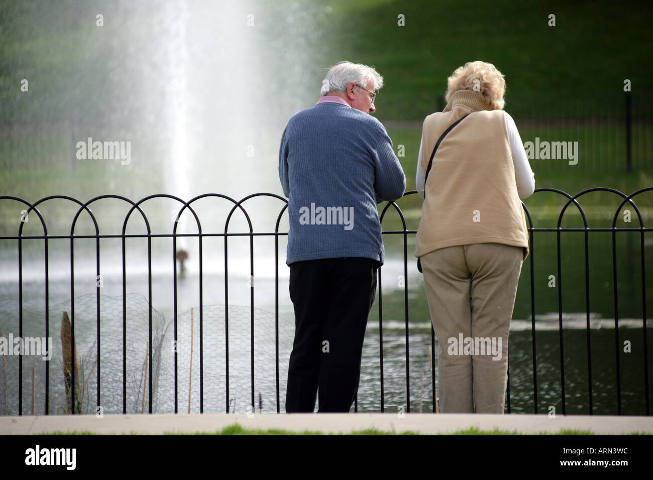 Ein paar in ihren späten fünfziger Jahren beobachtete einen Wasserstrahl an der Park, Maldon, Essex, England UK. NUR ZUR REDAKTIONELLEN VERWENDUNG Stockfoto