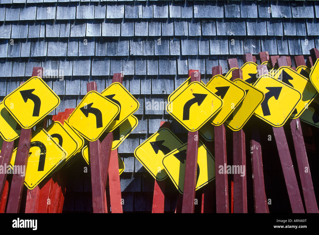 Kurve vor Wegweiser gebündelt zusammen gegen Zedern Holzschindeln Wand, Britisch-Kolumbien, Kanada. Stockfoto