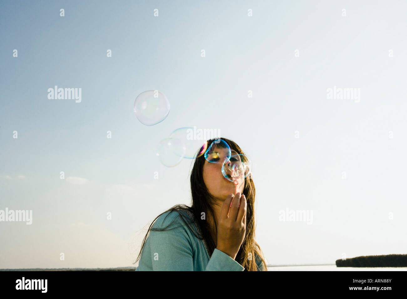 Mädchen blowing Bubbles von See Stockfoto