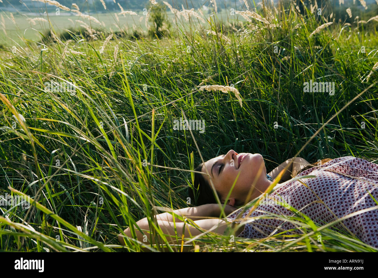 Junge Frau im Gras liegen Stockfoto