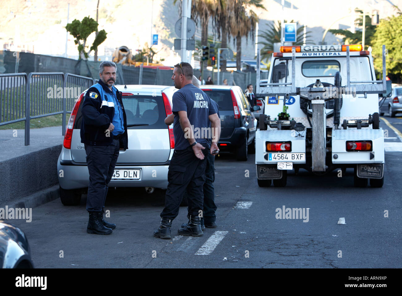 Grua Katz-und-Maus-Spiel und Kanarischen Polizei LKW Abschleppen vorbereiten zu schleppen illegal geparkten Autos in Santa Cruz-Teneriffa-Kanarische Inseln-Spanien Stockfoto