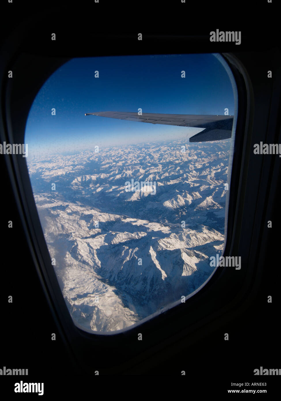 Blick aus dem Fenster einer Boeing 737-800 fliegen hoch über die Alpen-Gebirge Europas Stockfoto