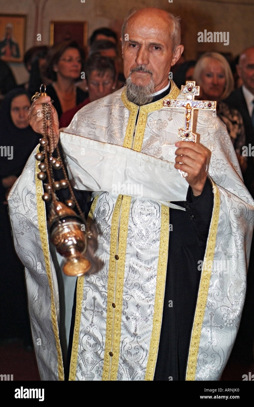 Östlichen orthodoxen Priester schwingen ein Weihrauchfass mit Weihrauch im Inneren, die Gemeinde während einer Hochzeitszeremonie Cense Stockfoto