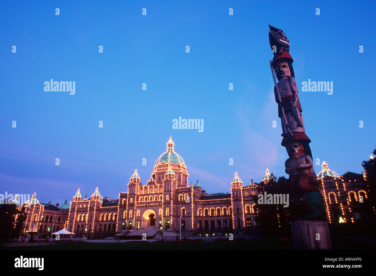 Totempfahl mit Parlamentsgebäude über Victoria, Vancouver Island, British Columbia, Kanada. Stockfoto