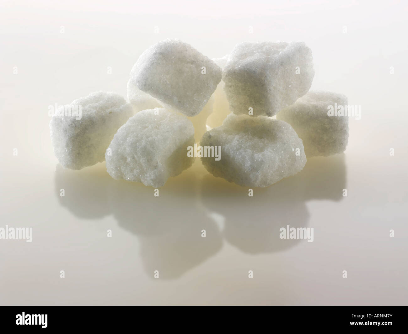 Roh geschnittene weiße Zuckerwürfel noch Leben gegen ein Weiß Hintergrund Stockfoto