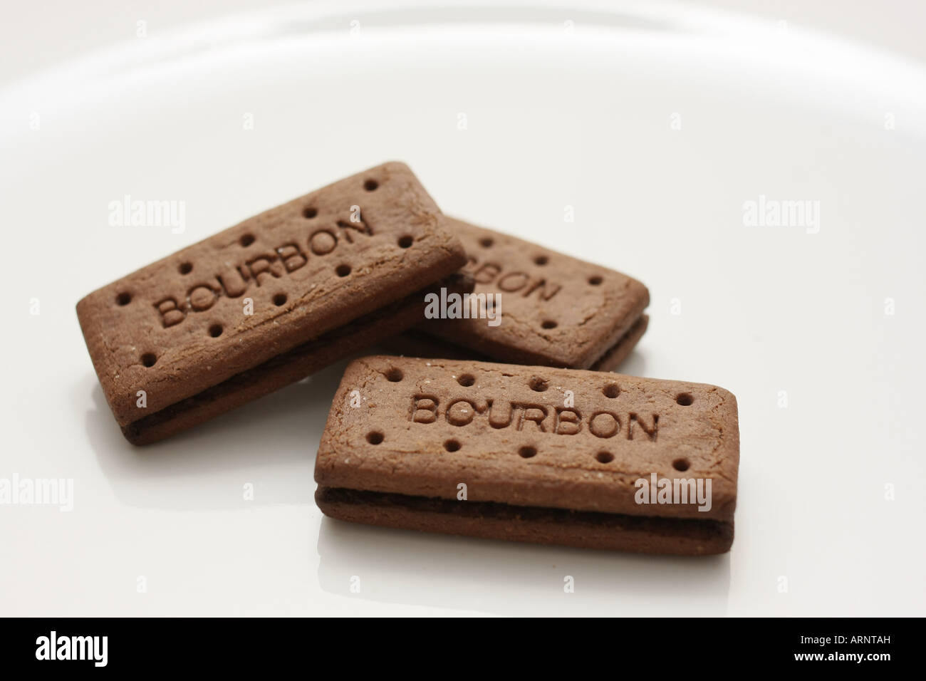 Drei Bourbon Kekse auf einem weißen Teller angeordnet Stockfoto