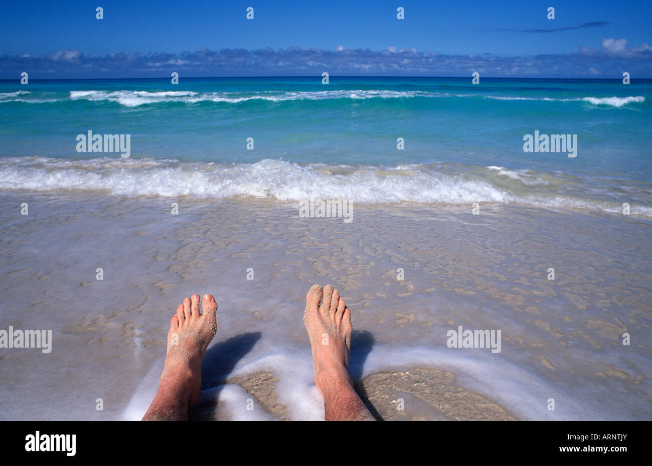 Mannes Füße am Rand des karibischen Meeres in Cancun Mexiko Stockfoto