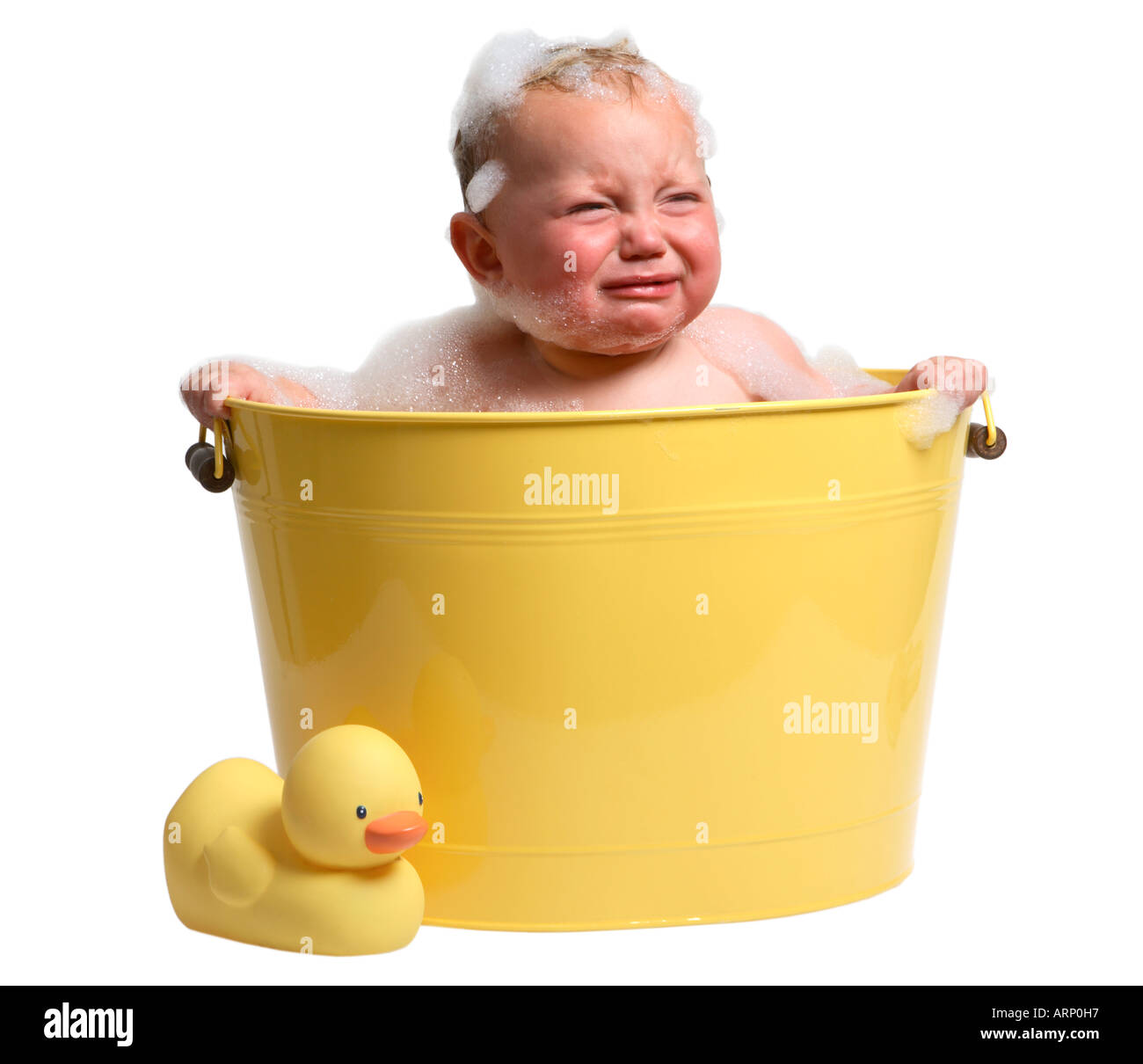 Baby in gelben Badewanne mit traurigen Gesicht. Stockfoto