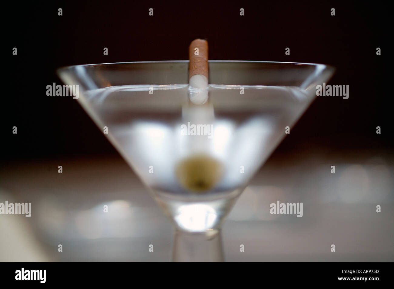 Martini mit einer Zigarette als einem Zahnstocher garnieren zu halten Stockfoto