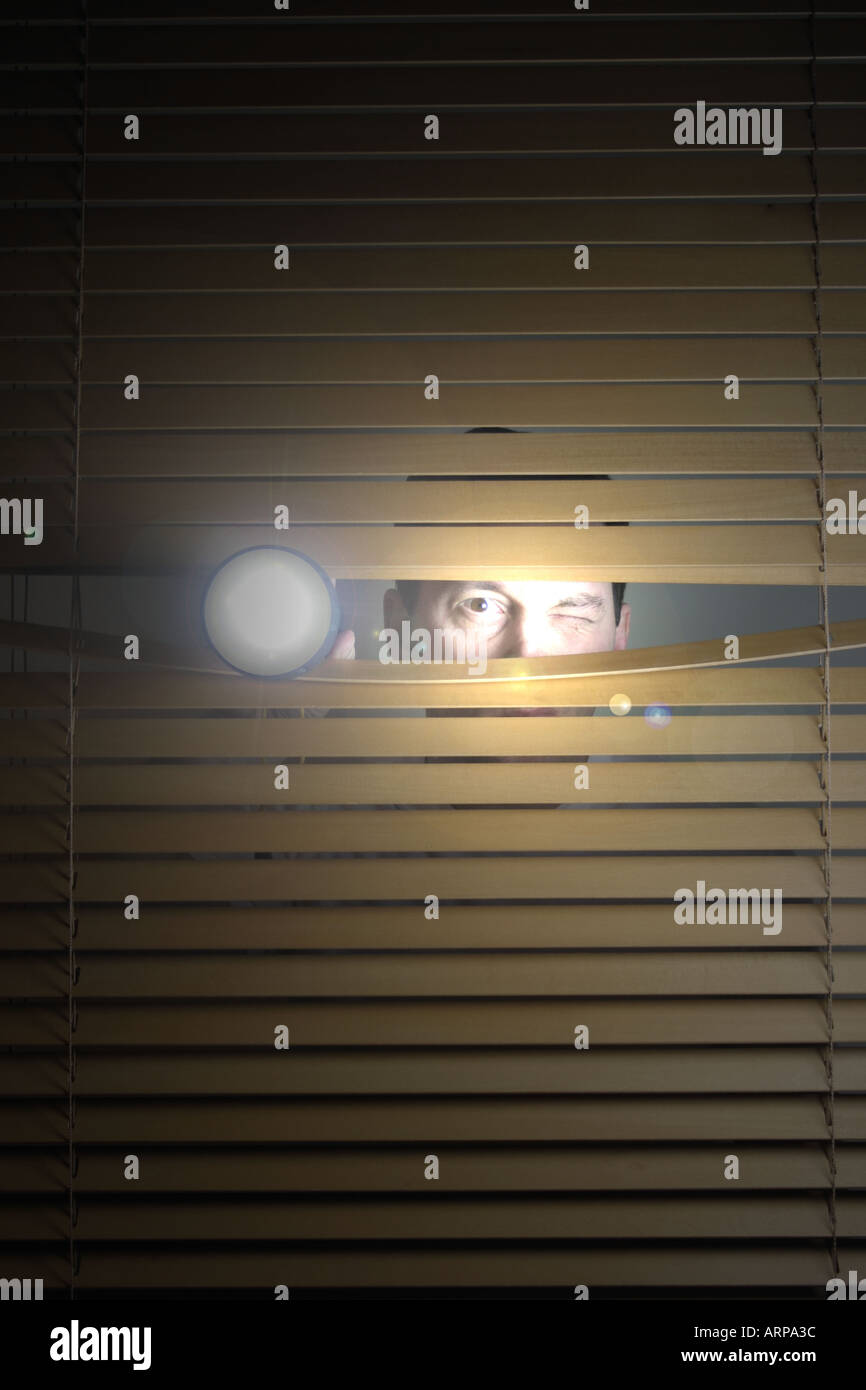 Man blickt durch Fenster Blind mit Fackel auf und sein Gesicht leuchtet  durch Licht Stockfotografie - Alamy