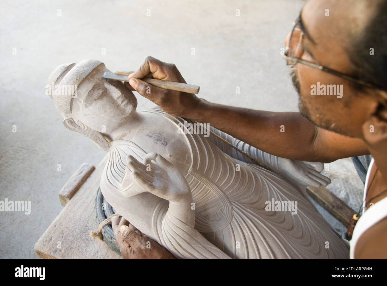 Ein Fachmann schnitzen eine Buddha-Statue aus Stein in Indien Stockfoto