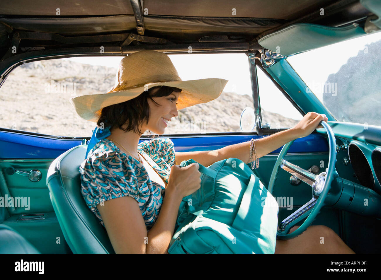 Frau im Auto mit Tasche Stockfoto