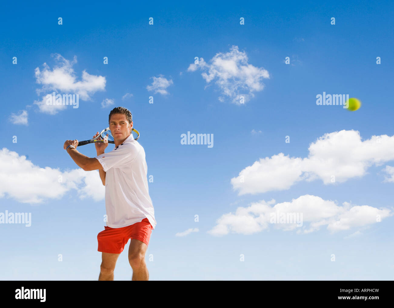 Mann mit dem Tennisspielen gegen blauen Himmel Stockfoto