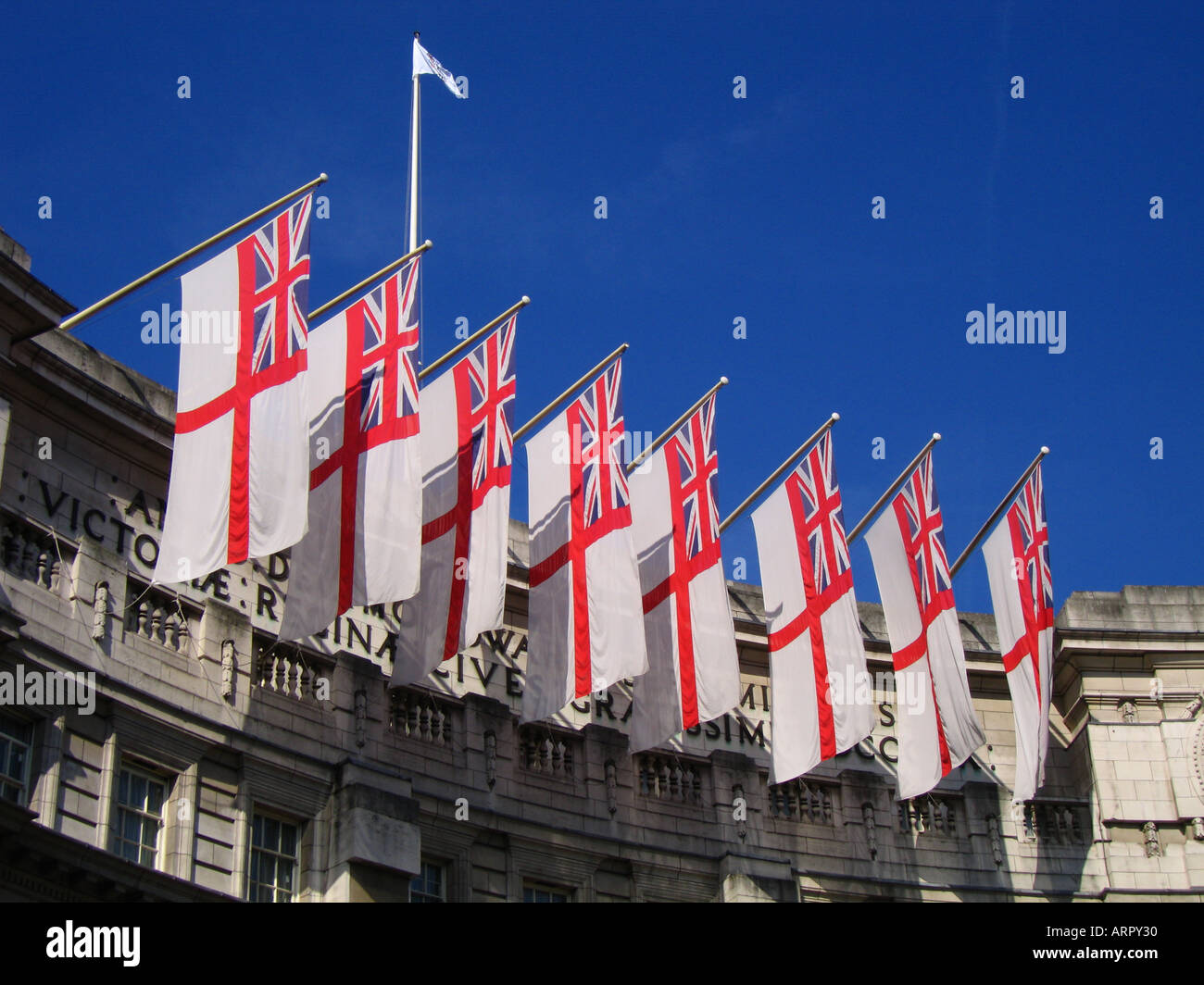 Weiße Fähnrich-Flaggen fliegen über Admiralty Arch The Mall City of Westminster London UK Stockfoto