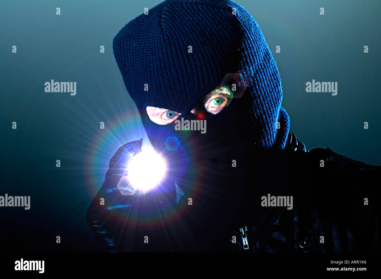 Mann mit Taschenlampe mit Ski-Maske Stockfoto