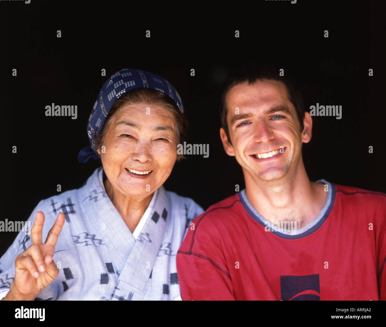 Ältere Dame von Okinawa mit westlichen Jüngling. Stockfoto