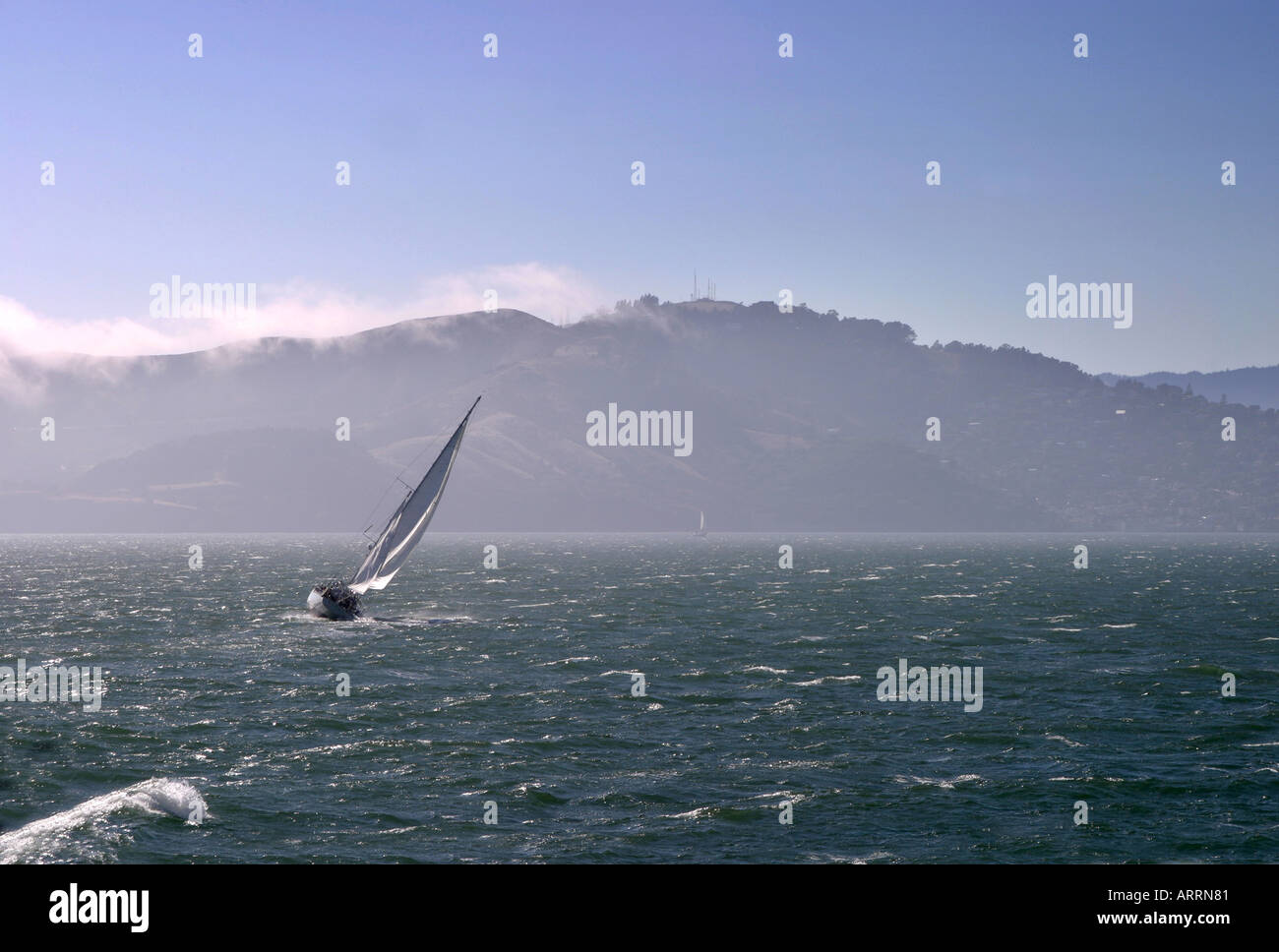 Eine Yacht Segeln an der San Francisco Bay mit Nebel den Hügeln, überrollen Kalifornien USA Stockfoto
