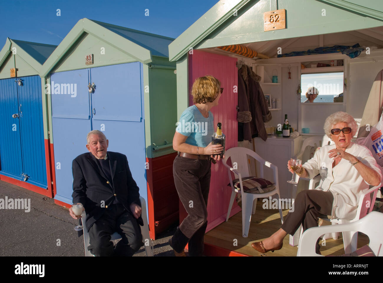 Menschen, die Entspannung bei ihrer Strandhütten der Esplanade in Hove in der Nähe von Brighton England Uk Stockfoto