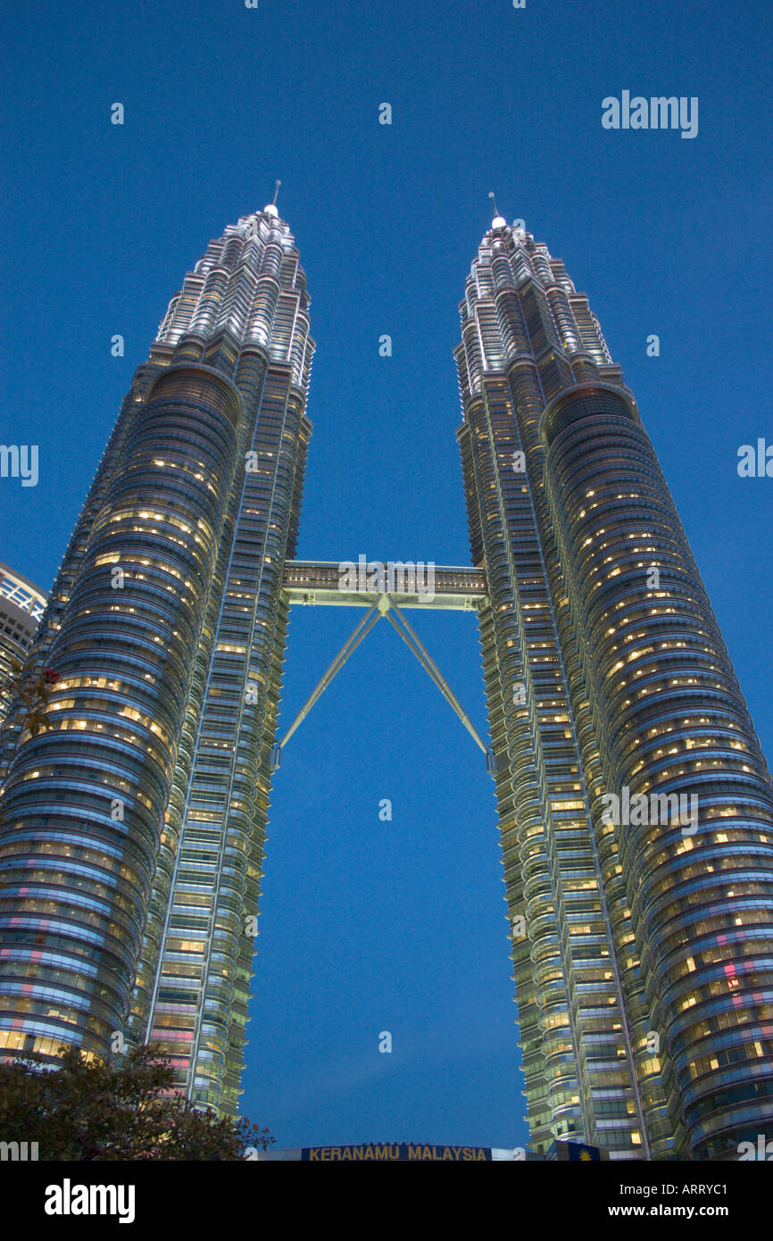 Petronas Twin Towers in der Abenddämmerung mit blauem Himmel beleuchtet Stockfoto