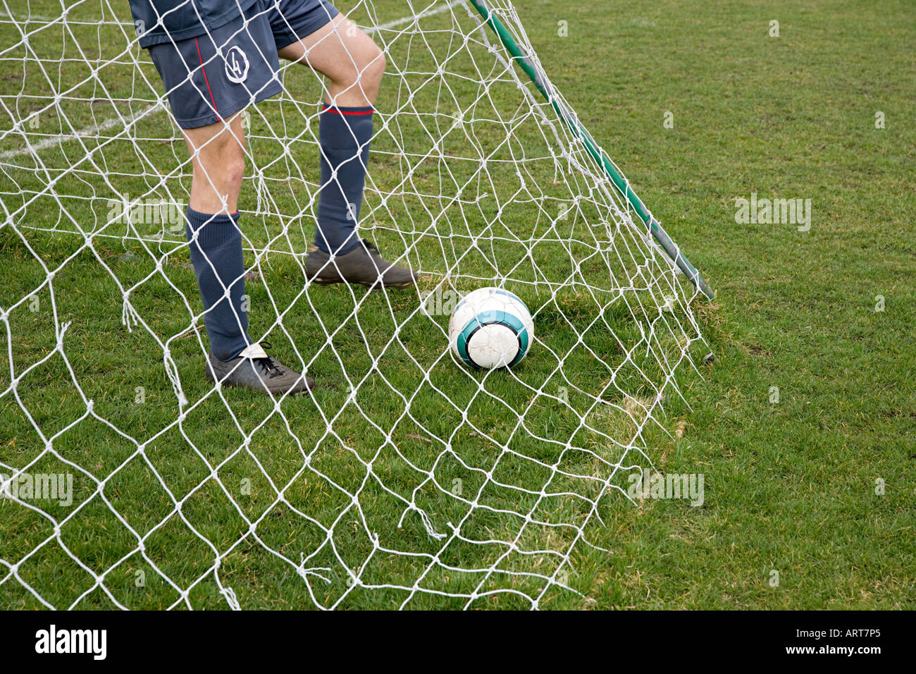 Fußballer im Tor mit Fußball Stockfoto