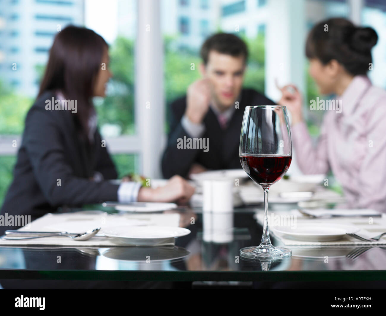 Geschäftsleute im Chat, Weinglas Vordergrund Stockfoto