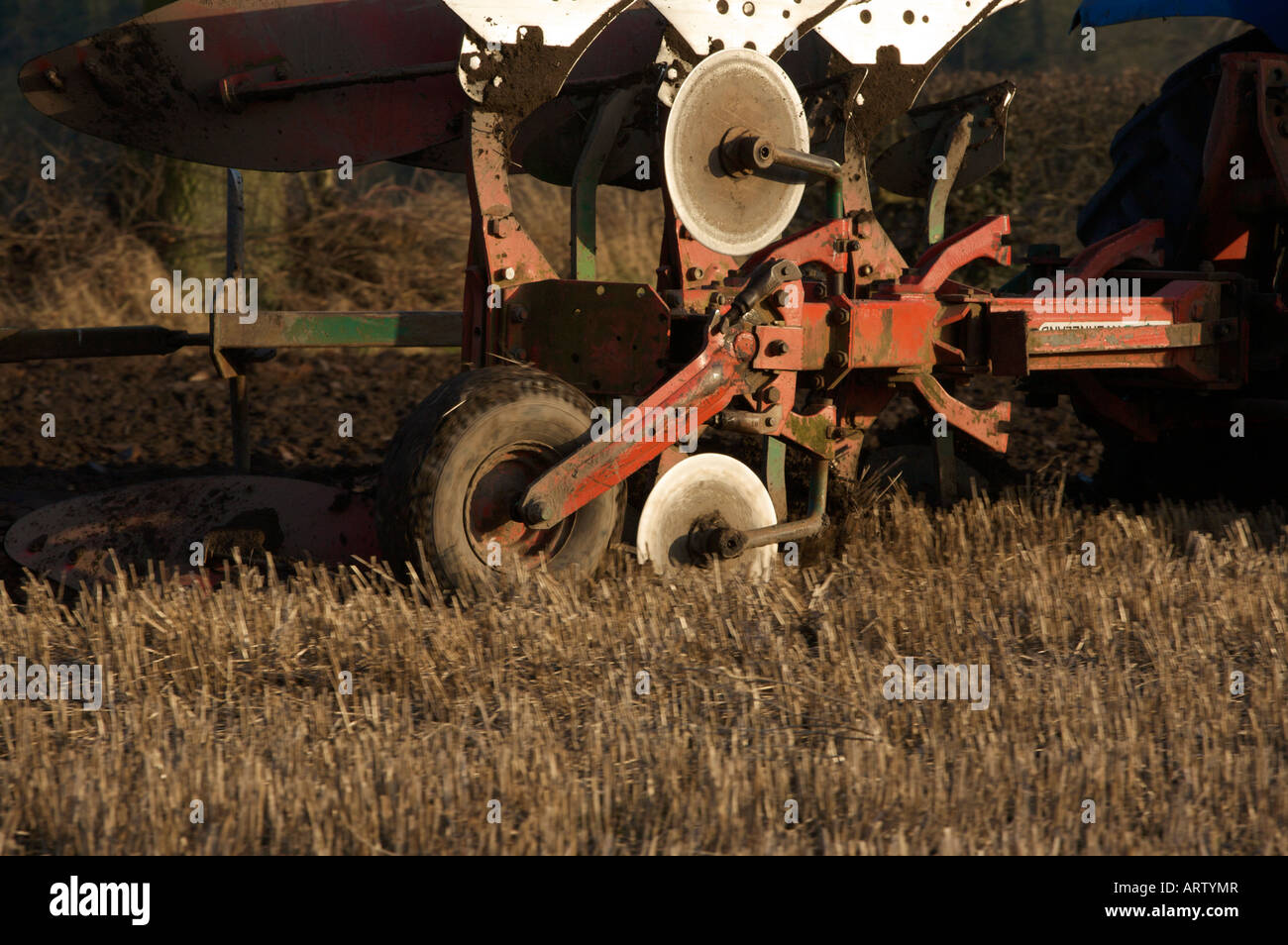 Drei Furche reversible Pflug hinter New Holland Traktor Pflügen auf einem Stoppelfeld bereit, Gerste UK zu Pflanzen Stockfoto