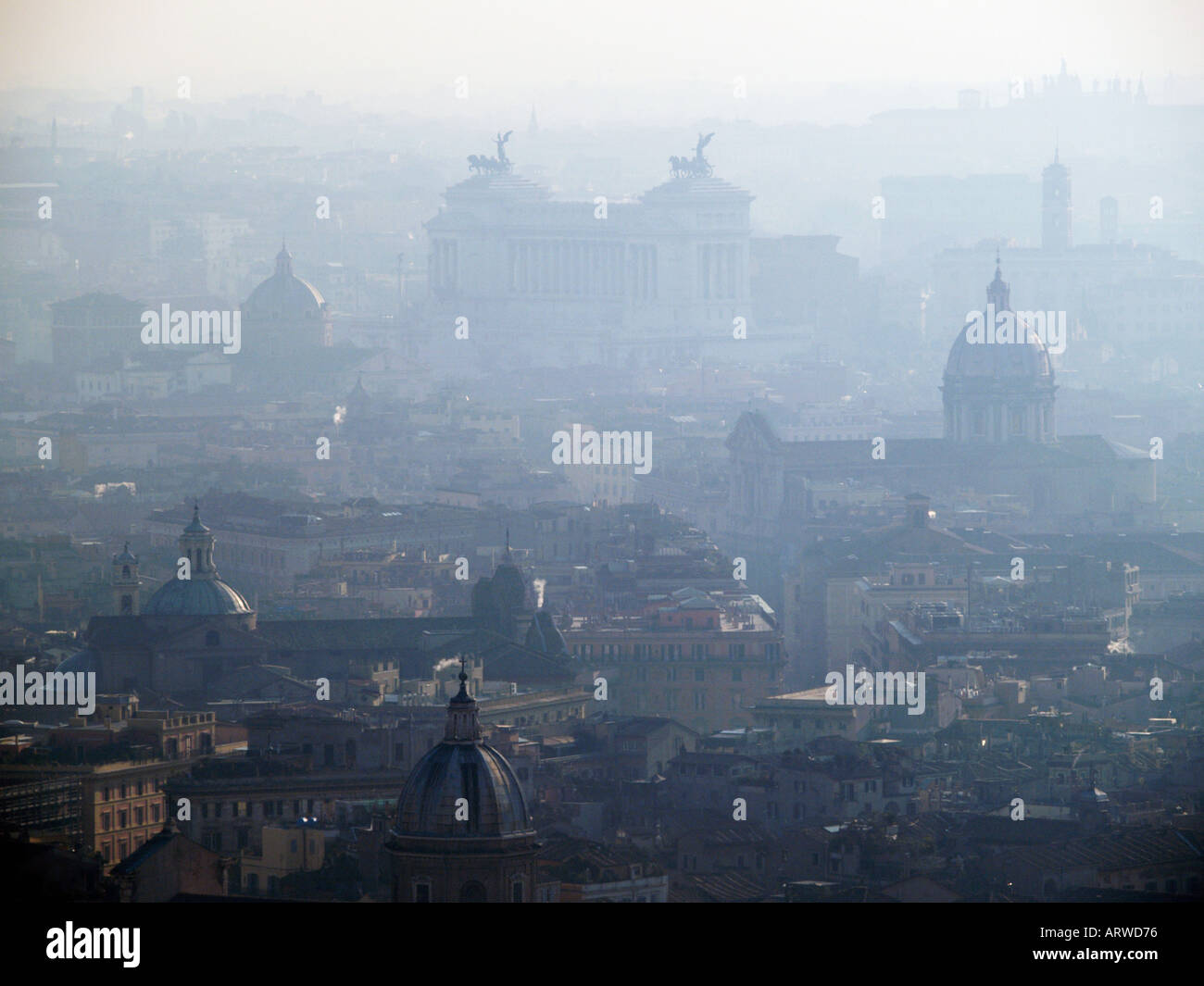 Sehen Sie sich auf eine trübe Rom mit mehreren Kuppeln und Victor Emmanuel II Monument in der hinteren Rom Stadt Smog Verschmutzung Stockfoto