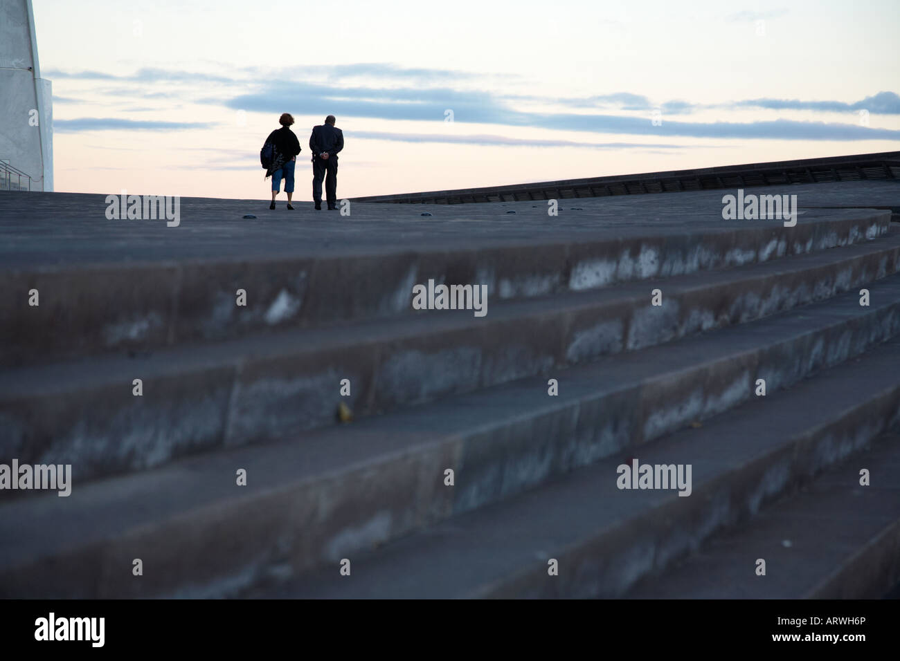 einzelne einsame Frau mit Wachmann zu Fuß entfernt von Schritten auf den leeren Bereich im Santa Cruz-Teneriffa-Kanarische Inseln-Spanien Stockfoto